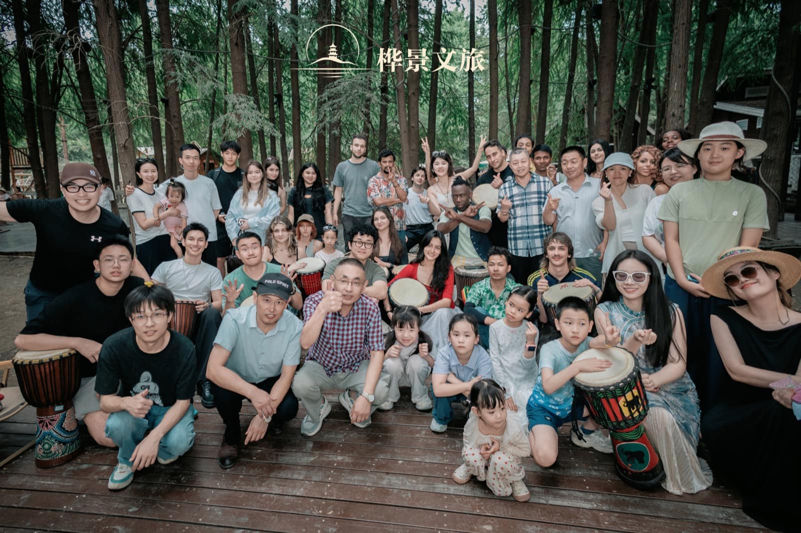 Families and fellow participants pose together among the trees